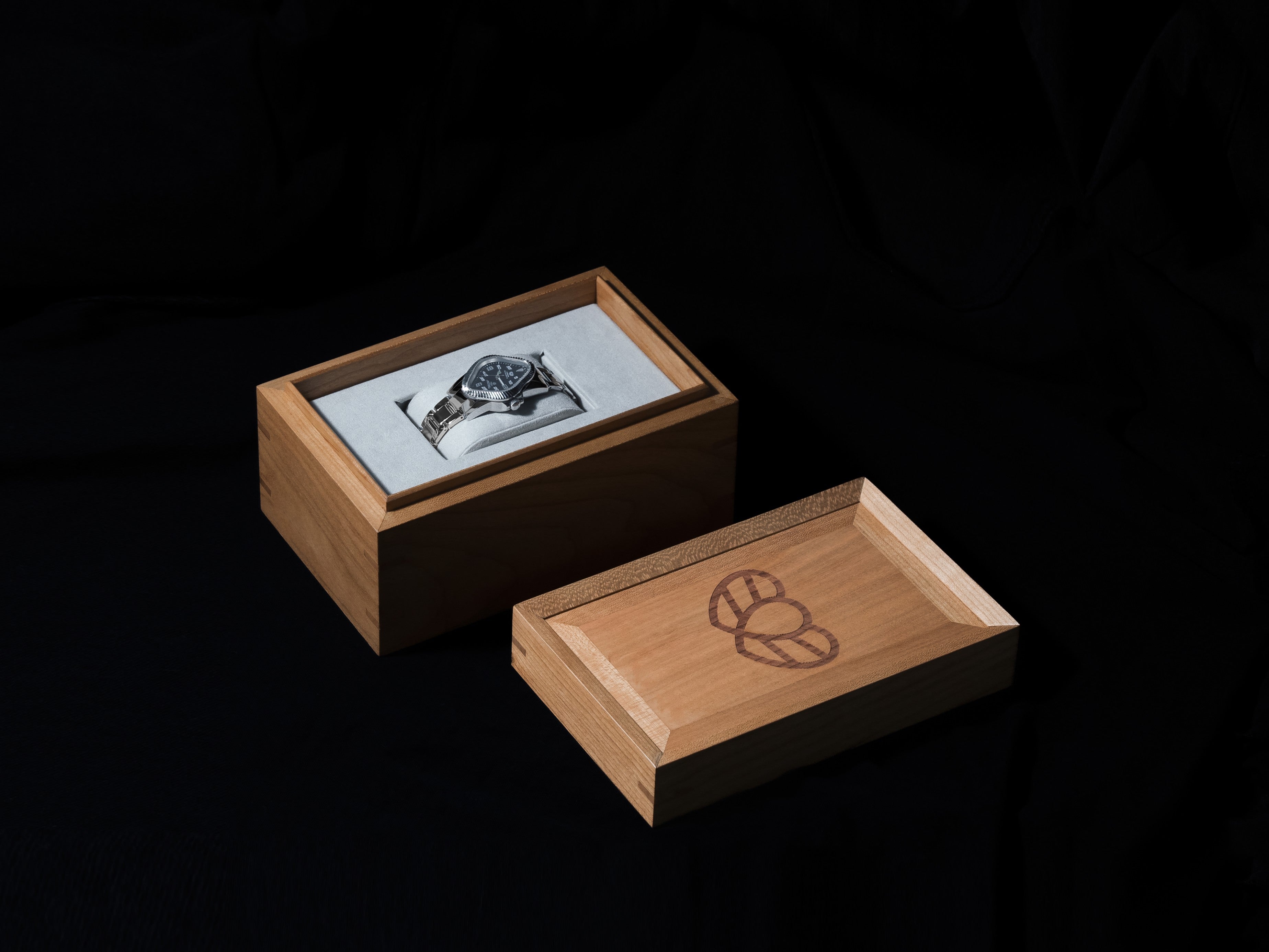 Open wooden box with PEA106-PGY on removable pillow illustrating limited-edition display